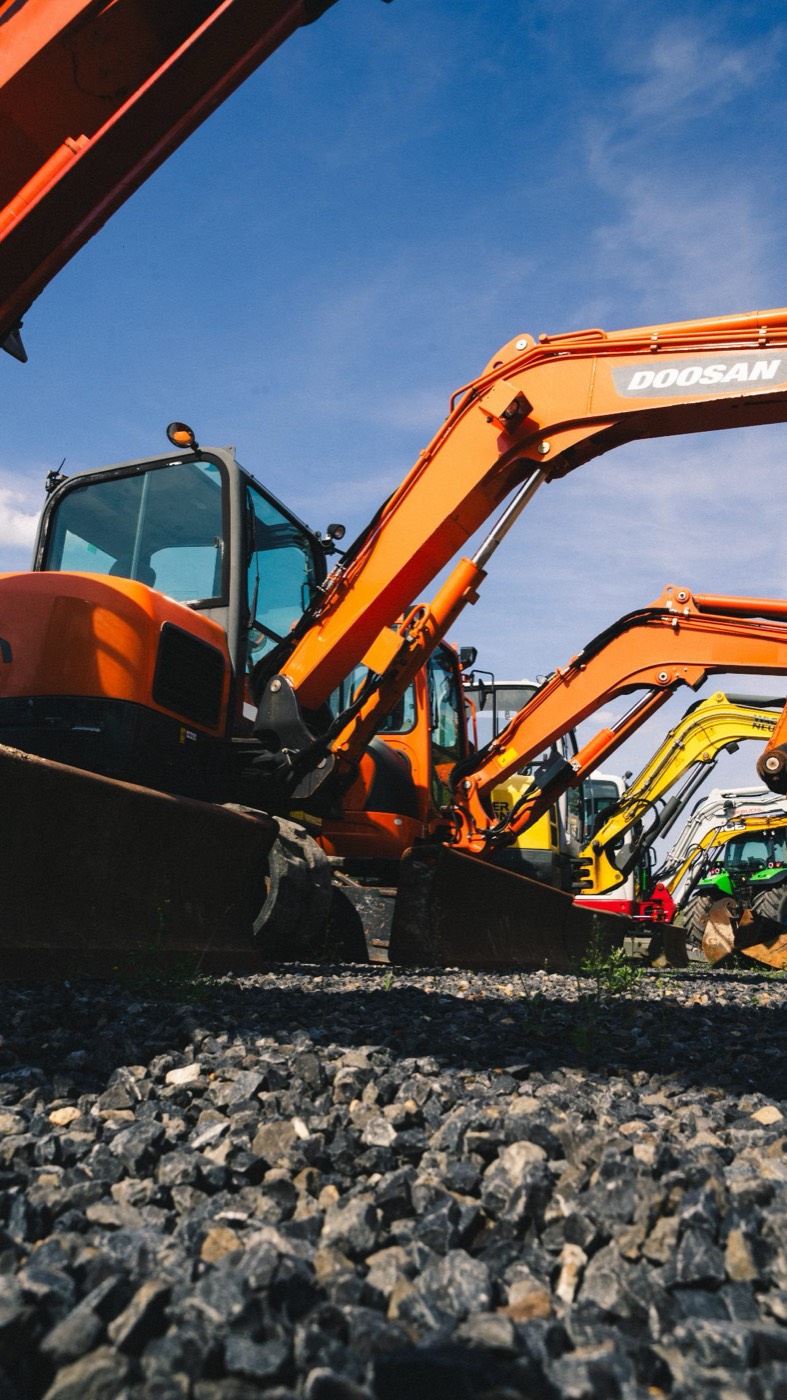 Excavators on a yard, the kind of machine Sell Any Machine buys